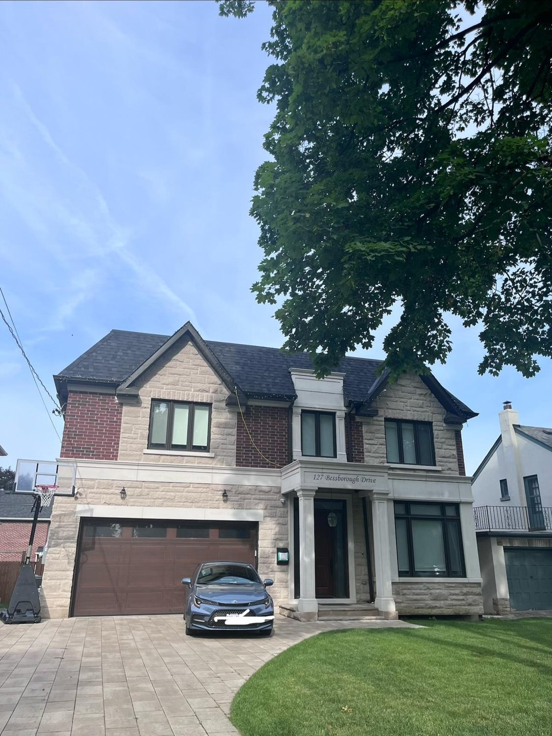 Front elevation of the Bessborough custom home by Danclair Construction, brick and stone facade with double garage